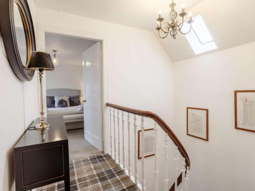 a hallway with a staircase with a table and a mirror at 4 Bed in Wick 91390 in Wick