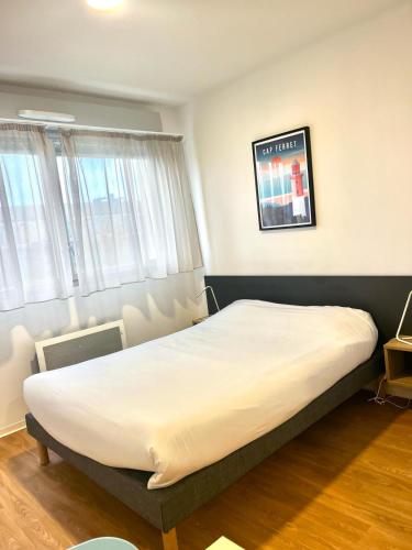 a bedroom with a large bed in a room at Résidence Hôtelière Le Prado in Libourne