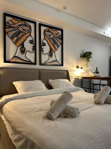a white bed with three pictures on the wall at Sea side 87 Sweet Me Eilat אילת in Eilat