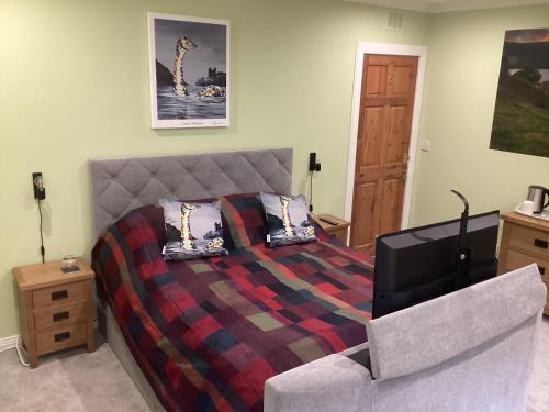 a bedroom with a bed and a couch at Taigh Sealladh Fèidh B&B in Fort Augustus