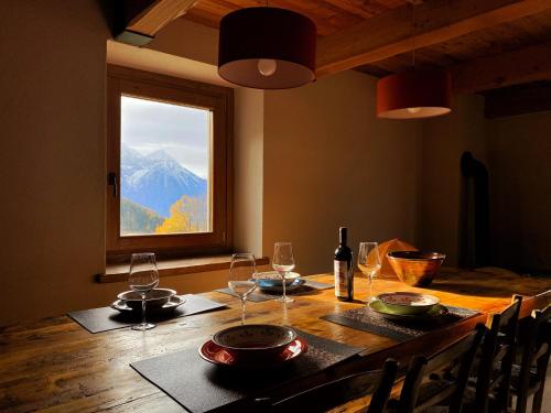 a table with wine glasses and a view of a mountain at Baita La Pesse - Ad un passo dalle stelle in Nus
