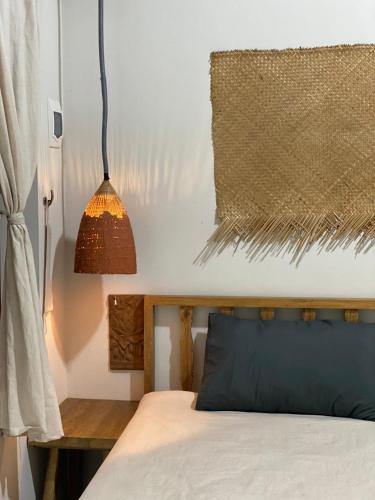 a bedroom with a bed and a hanging lamp at Nhà Lúa Homestay in Ninh Binh