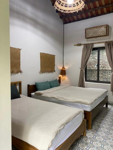 a bedroom with two beds and a window at Nhà Lúa Homestay in Ninh Binh