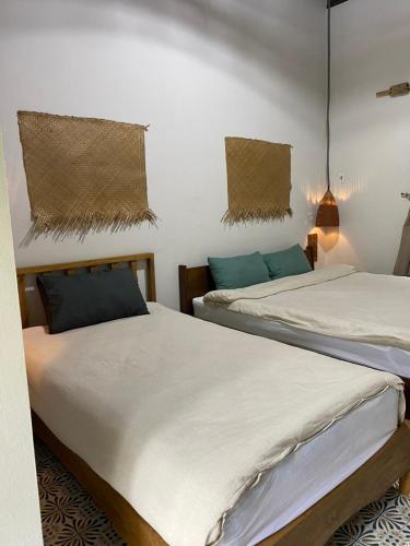 two beds sitting next to each other in a room at Nhà Lúa Homestay in Ninh Binh
