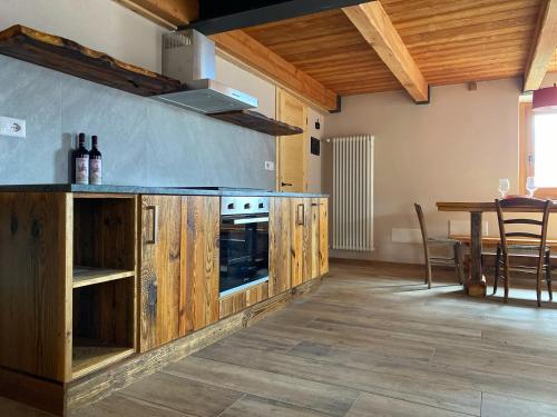 a kitchen with wooden cabinets and a table with chairs at Baita La Pesse - Ad un passo dalle stelle in Nus