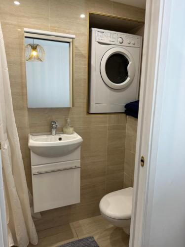 a bathroom with a toilet and a washing machine at RELAX HOME Maison et studio ensemble in Deauville