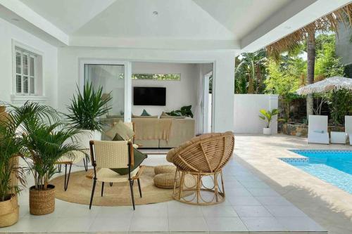 a living room with a table and chairs and a pool at The White Villa in Lipa in Lipa