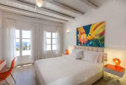 a bedroom with a white bed and a painting on the wall at Fortan 5* villa in Mýkonos City