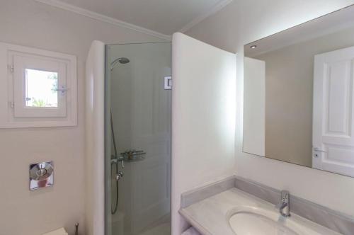 a bathroom with a shower and a sink and a mirror at Fortan 5* villa in Mýkonos City