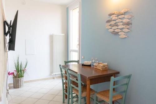 een eetkamer met een houten tafel en blauwe stoelen bij Le Camere di Olivia in Ravenna