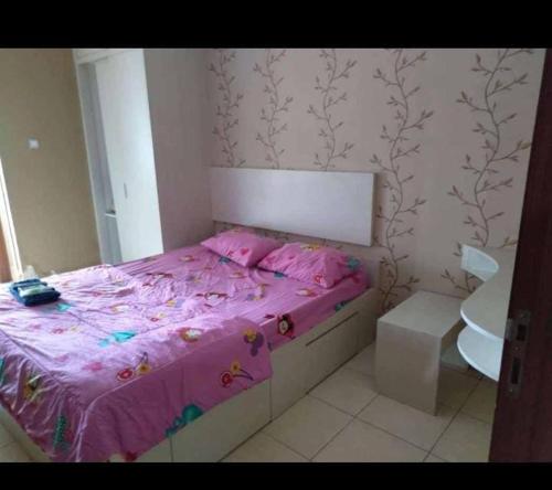 1 dormitorio con cama rosa y lavamanos en Mega Room 69, en Pondokcabe Hilir