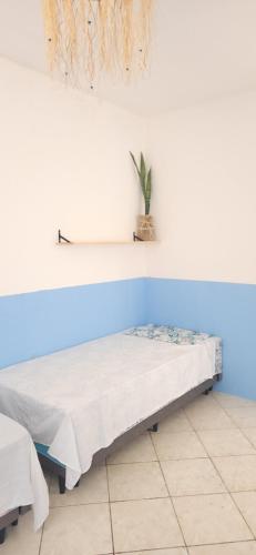 uma cama num quarto com uma prateleira na parede em Afrolar - Vizinhas de Iemanjá em Salvador