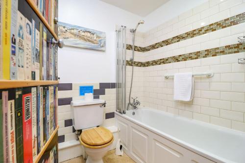 a bathroom with a toilet and a bath tub at The Old Signal House in Niton