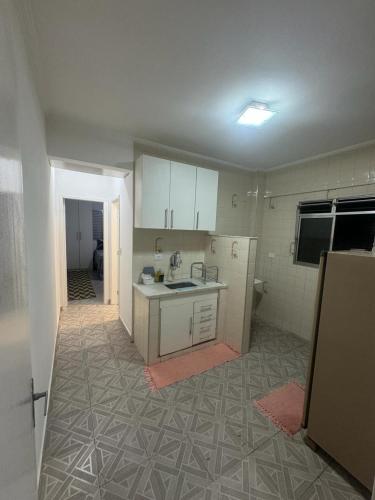 a kitchen with white cabinets and a counter top at Apartamento em Praia Grande in Praia Grande