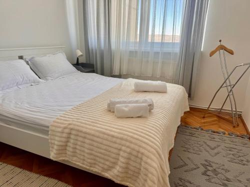 a bedroom with a bed with two towels on it at Panoramic Apartment in Odorheiu Secuiesc