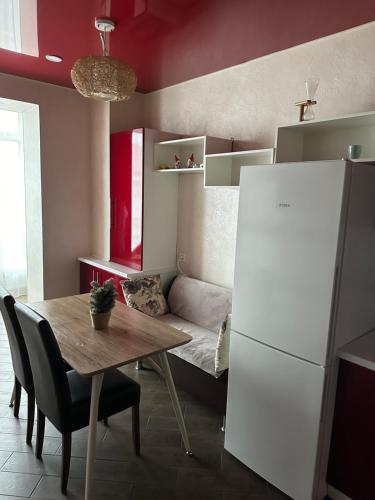eine Küche mit einem Tisch und einem weißen Kühlschrank in der Unterkunft Sweet Home in Dnipro
