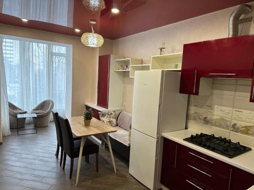 eine Küche mit einem Tisch und einem Kühlschrank sowie einem Tisch und Stühlen in der Unterkunft Sweet Home in Dnipro