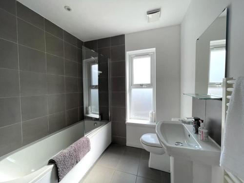 a bathroom with a sink and a tub and a toilet at Contemporary-styled 3-Bed House in Buckinghamshire