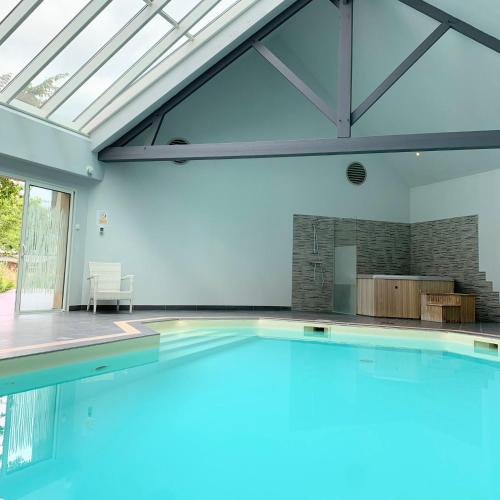 - une piscine dans une maison avec une grande fenêtre dans l'établissement Logis Auberge Bienvenue, à Doué-la-Fontaine