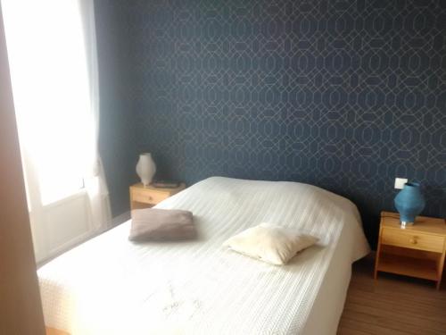 ein Schlafzimmer mit einem Bett mit zwei Kissen darauf in der Unterkunft Résidence de la plage in Ouistreham