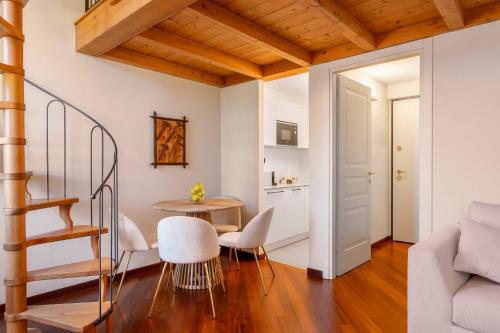 a room with a staircase and a table and chairs at Villa Raggi Relais in Castelletto d'Orba