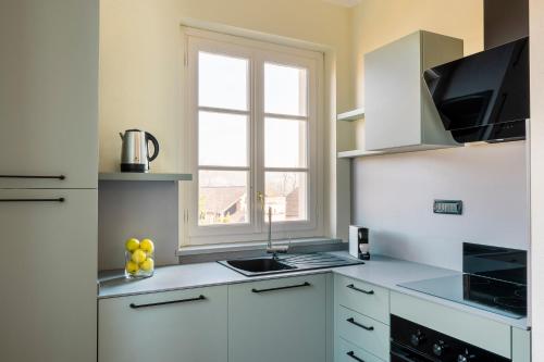 a white kitchen with a sink and a window at Villa Raggi Relais in Castelletto d'Orba