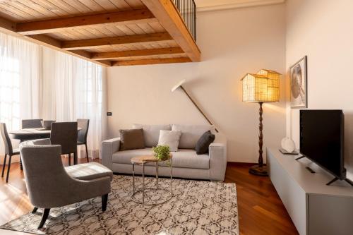 a living room with a couch and a tv at Villa Raggi Relais in Castelletto d'Orba