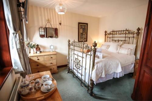a bedroom with a bed and a dresser and a table at The Shepherd's Purse in Whitby