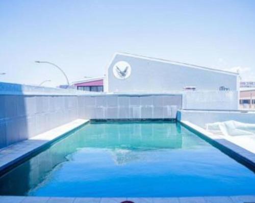 a swimming pool with blue water in front of a building at Movic's Modern Airbnb in Windhoek