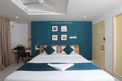 Naksha Tree Hotels, Honey Crest- Ramapuram في تشيناي: غرفة نوم بسرير كبير بجدار ازرق