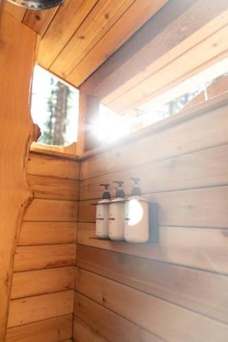a bathroom with two candles on a wooden wall at Persis tiny cabin. amazing outdoor shower. in Sultan