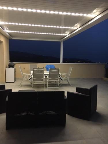 Zimmer mit Tisch, Stühlen und Beleuchtung in der Unterkunft Sublime in Albitreccia