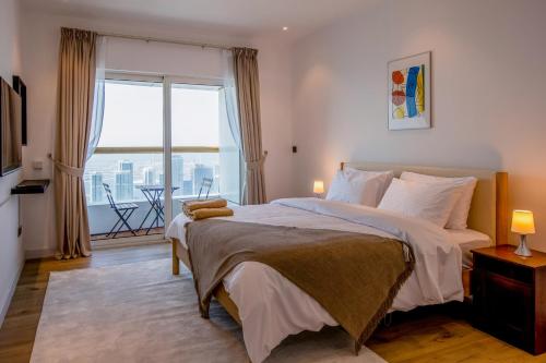 a bedroom with a large bed and a large window at Deluxe - Sea view - Dubai Marina in Dubai
