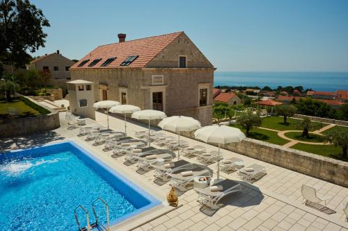 a swimming pool with lounge chairs and a house at Palace Natali in Dubrovnik