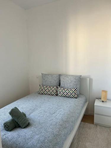 une chambre avec un lit avec des oreillers dessus dans l'établissement L'alberto-Appartement centre ville Beziers- Wifi -Balcon -Clim, à Béziers