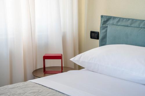 a bedroom with a bed and a red chair at Villa Raggi Relais in Castelletto d'Orba