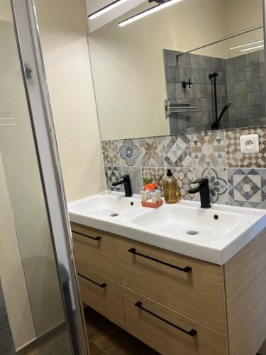 W łazience znajduje się umywalka i lustro. w obiekcie Maison avec piscine chauffée - 8 personnes - Sud Réunion w mieście Saint-Joseph