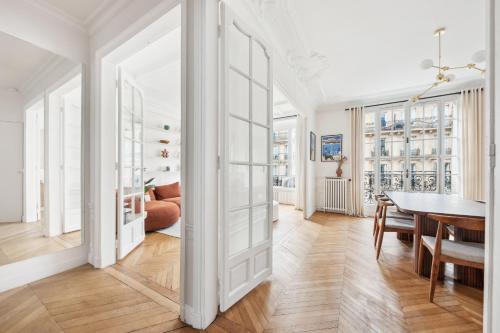 Cette chambre blanche dispose d'une table et d'une salle à manger. dans l'établissement Charming and cosy apartment in Paris Center, à Paris