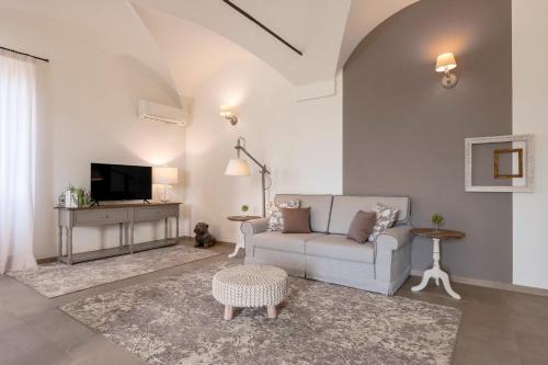 a living room with a couch and a tv at Villa Raggi Relais in Castelletto d'Orba