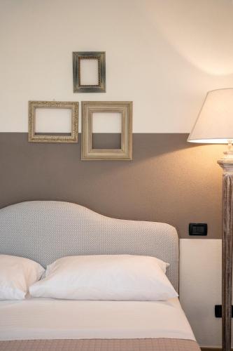 a bedroom with a bed and three mirrors on the wall at Villa Raggi Relais in Castelletto d'Orba
