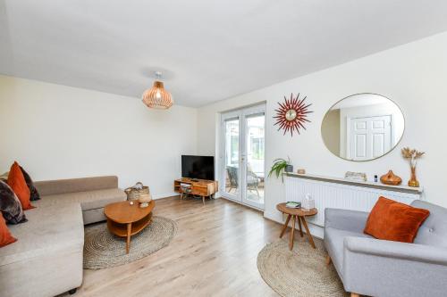 a living room with a couch and a mirror at Beautiful stay next to lakes and river in Nottingham