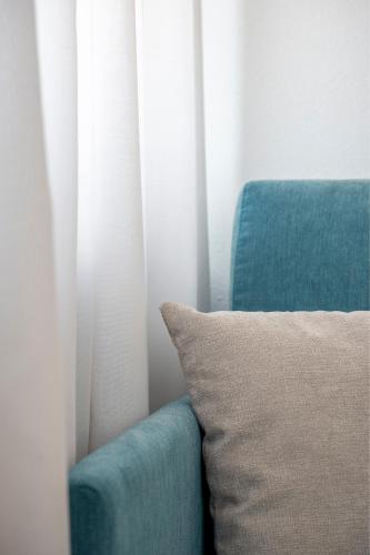 a blue couch with a pillow next to a window at Villa Raggi Relais in Castelletto d'Orba