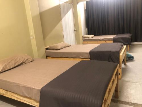 Habitación con 3 camas en una habitación en THE Pi HOMESTAY IMPHAL MANIPUR, en Imphal