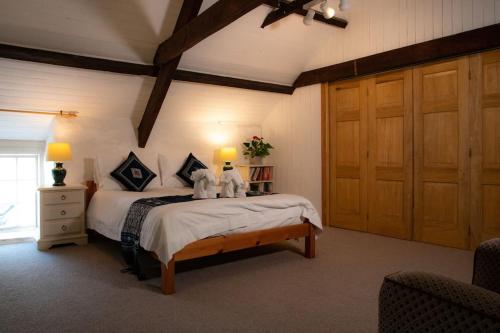 a bedroom with a bed with two stuffed animals on it at Yr Hen Efail - Old Smithy in Tregaron