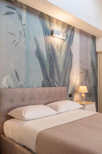a bedroom with a large mural of plants on the wall at Villa Raggi Relais in Castelletto d'Orba