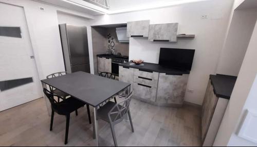 a small kitchen with a table and a kitchen with a counter at Casa MaLù 18 Cin I T 0 7 1 0 3 3 B 4 0 0 0 8 8 3 3 2 in Monte SantʼAngelo