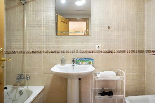 uma casa de banho com um lavatório e um espelho em Atico Coto de Santi Petri 122 em Chiclana de la Frontera
