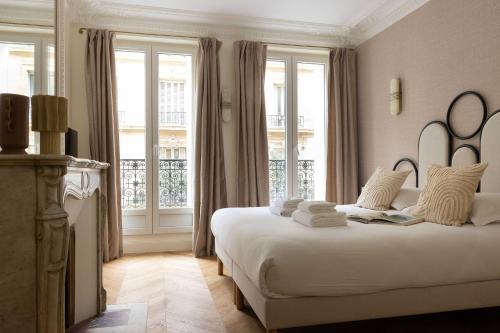 een slaapkamer met 2 bedden en een groot raam bij Sumptuous flat for 6 people Etoile in Parijs
