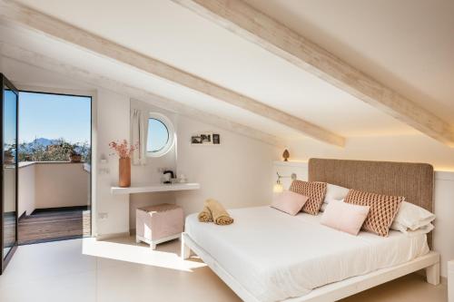 una camera da letto con un letto bianco e cuscini rosa di MelRose Relais a Massa Lubrense