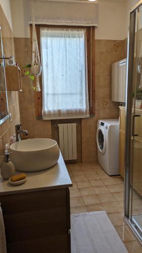 a bathroom with a sink and a washing machine at Casa Reggiana in Reggio Emilia